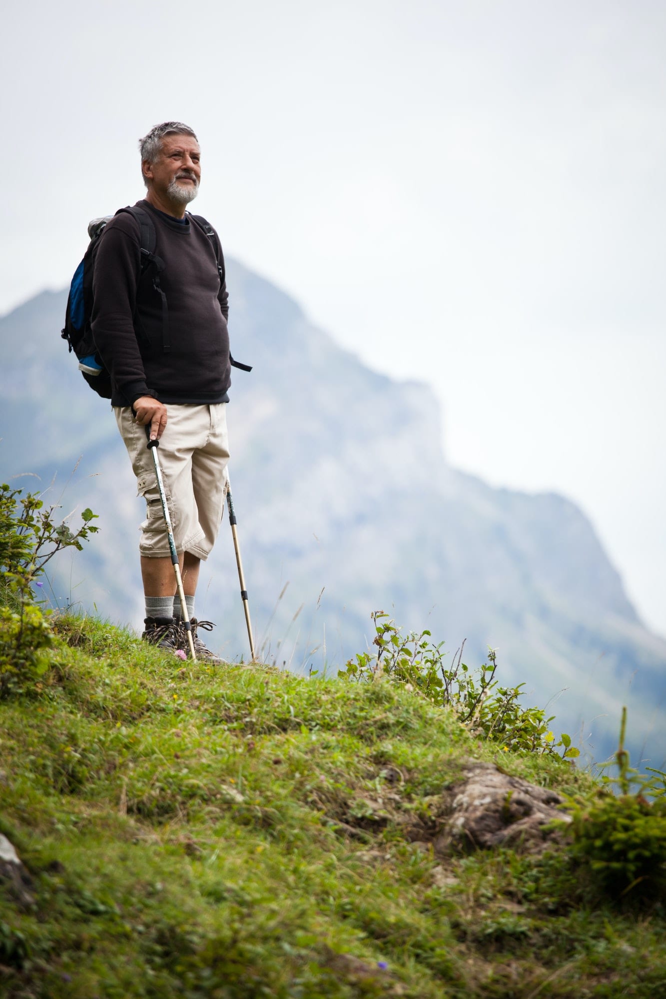 active handsome senior man nordic walking outdoors on a forest p