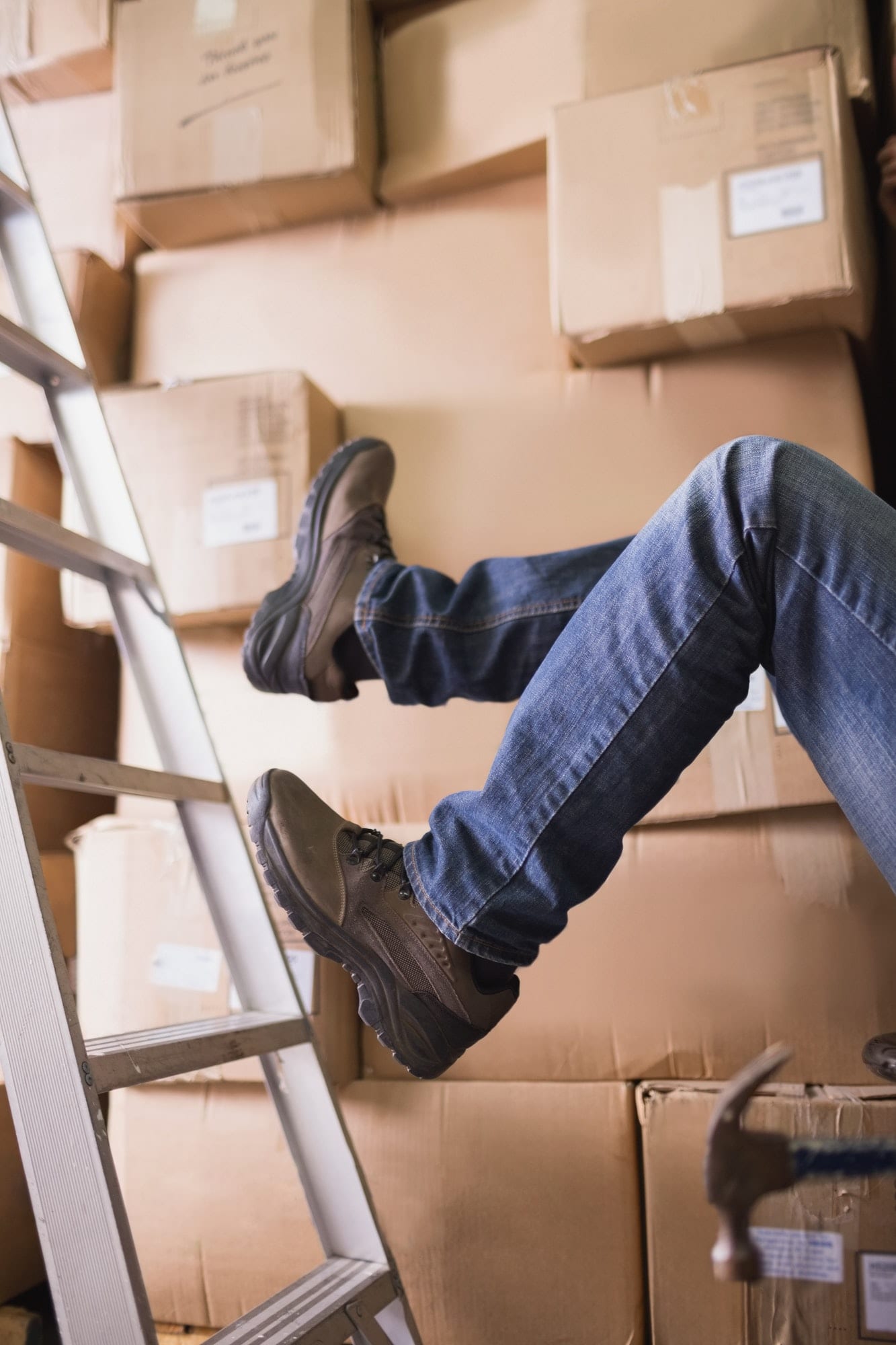 Low section of worker falling off ladder in the warehouse