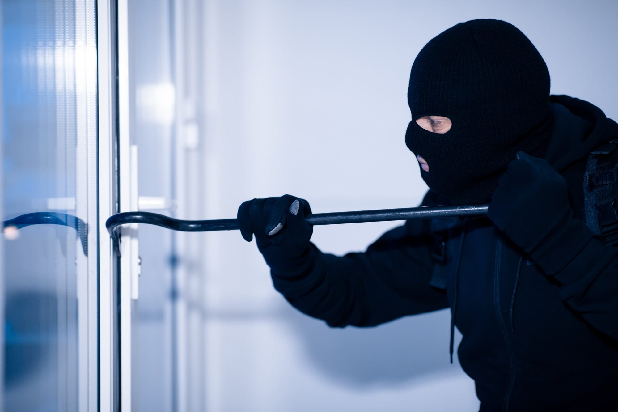 https://cleverseguros.co/wp-content/uploads/2020/07/robber-in-black-balaclava-cracking-door-with-crowbar.jpg