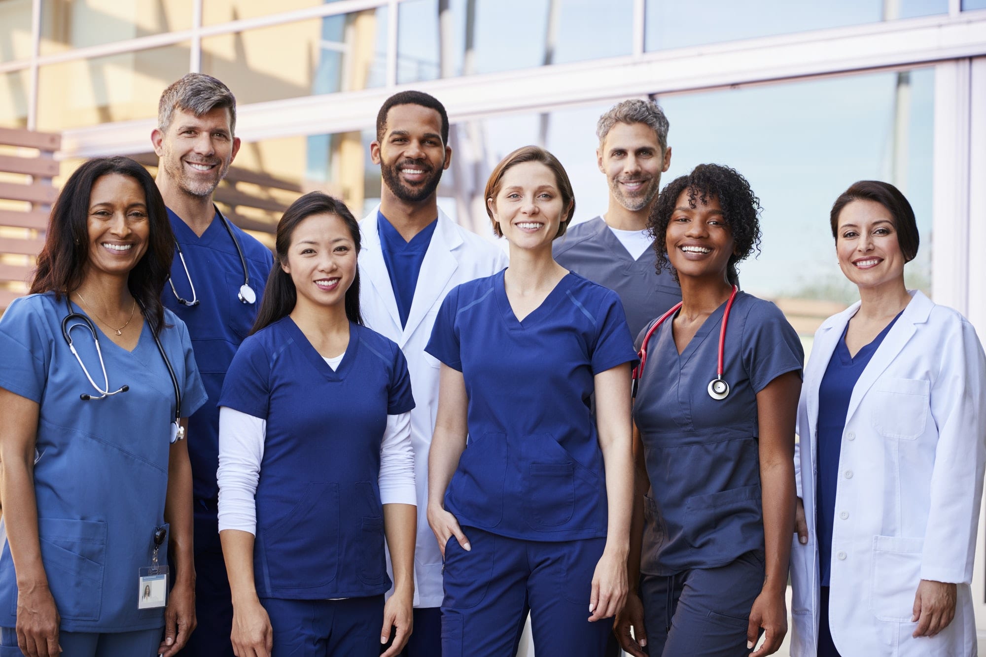 https://cleverseguros.co/wp-content/uploads/2020/07/smiling-medical-team-standing-together-outside-a-hospital.jpg